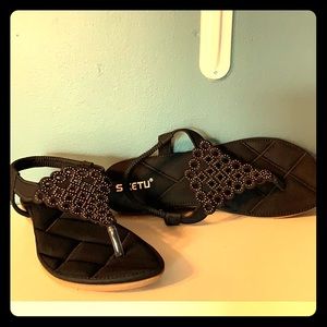 Women’s black sandals with rhinestone design.